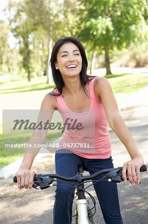 Young Woman Riding Bike In Park