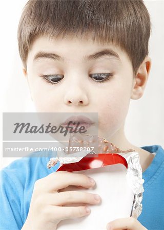 Image of the surprised boy with chocolate on white