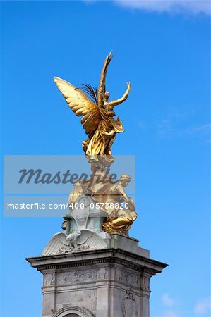 Gilded statue of Goddess of Victory on pinnacle of Queen Victoria Memorial. It's located right in front of Buckingham Palace, London.