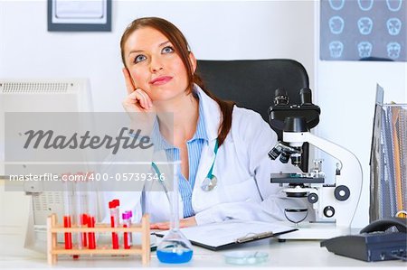 Female medical doctor sitting in cabinet and dreaming