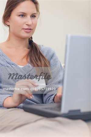 Portrait of a woman booking her holidays online in her living room