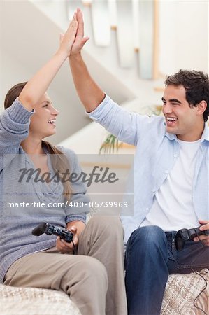 Portrait of a cheerful couple playing video games in their living room