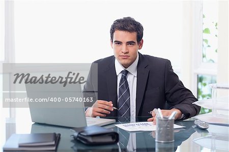 Businessman working with a laptop and a graph in his office
