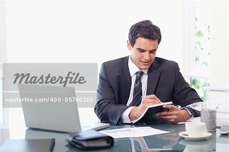 Businessman taking notes in his office