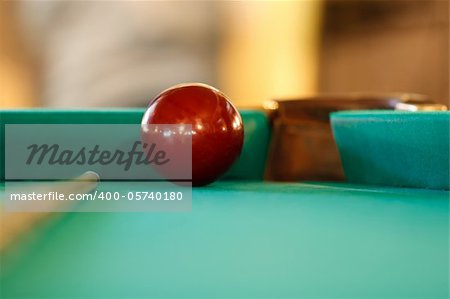 red cue ball at the pocket and the cue for Russian billiards