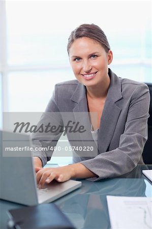 Portrait of a smiling businesswoman working with a laptop in her office