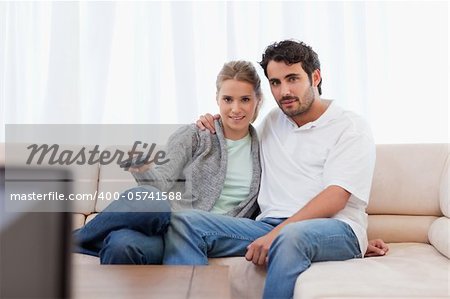 Lovely couple watching TV in their living room