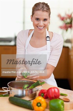 Portrait of a smiling woman cooking in her kitchen