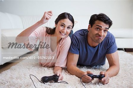 Woman beating her boyfriend while playing video games in their living room
