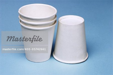 Stack of disposable paper cups on blue background