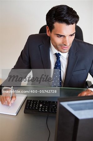 Portrait of a focused businessman taking notes in his office