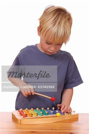 Portrait of a young boy playing a toy xylophone