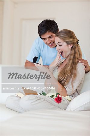 Portrait of a man offering a jewel to his fiance in their living room