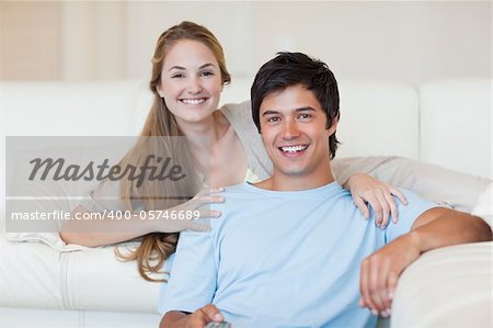 Smiling couple watching television in their living room