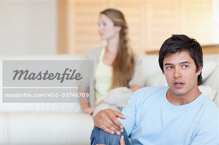 Sad couple arguing in their living room