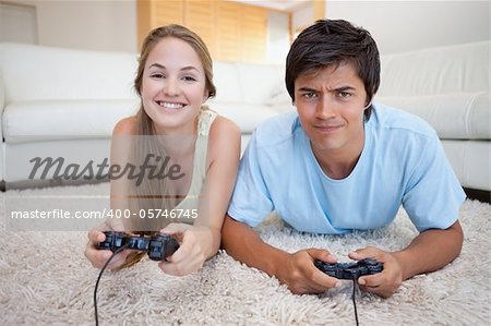 Couple joviale, jouer à des jeux vidéo dans leur salon