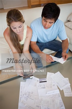 Portrait of a young couple looking at their bills in their living room