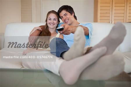 Relaxed lovely couple watching television in their living room