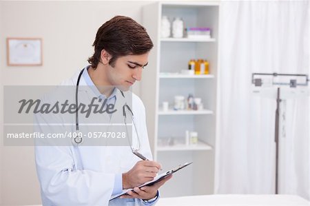 Young male doctor with clipboard