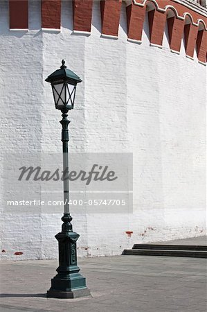 Old style street lamp in front of the wall of white brick. The Kremlin Kutafya tower fragment on Red Square in Moscow, Russia