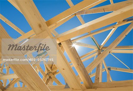 New residential construction home framing against a blue sky