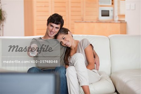 Young couple on the couch watching television together