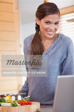 Young woman in the kitchen looking for the recipe online