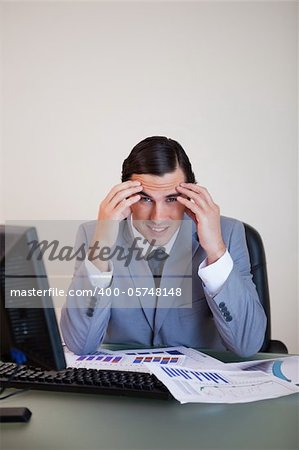 Frustrated young businessman working on statistics