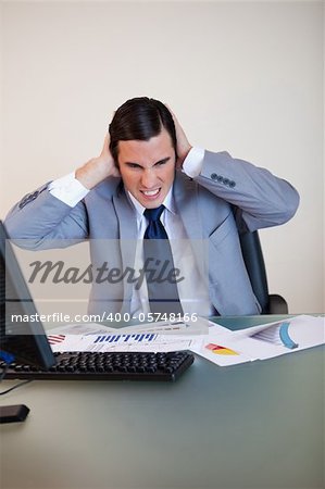 Angry businessman covering his ears