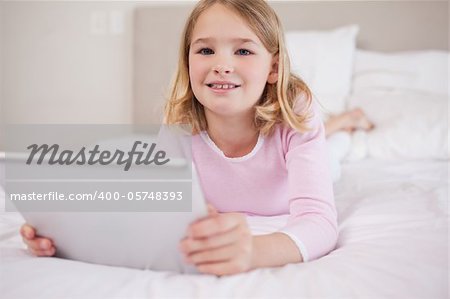 Girl using a tablet computer in a bedroom