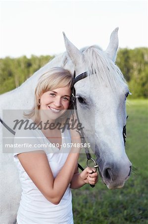 An attractive young woman with a horse