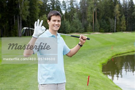 A young man with a stick and a ball on the golf course