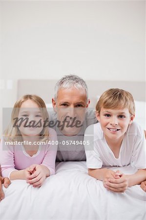 Portrait of siblings and their father posing in a bedroom