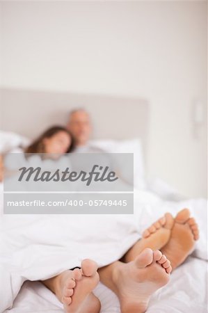 Portrait of a couple sleeping with the camera focus on their feet