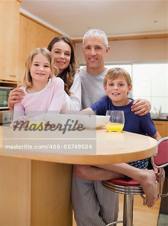 Portrait of a smiling family having breakfast in their kitchen