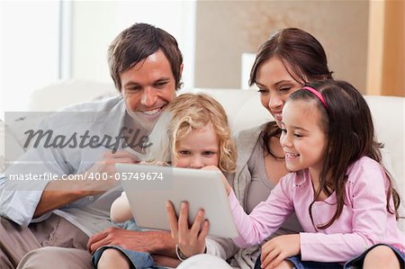 Delighted family using a tablet computer in a living room