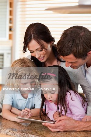 Portrait of a happy family using a tablet computer together in a kitchen