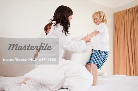 Playful family having pillow fight in a bedroom