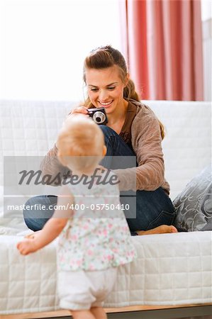 Young mother making photos of baby