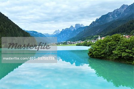 Tranquil summer Italian dolomites mountain lake and village view (Auronzo di Cadore)