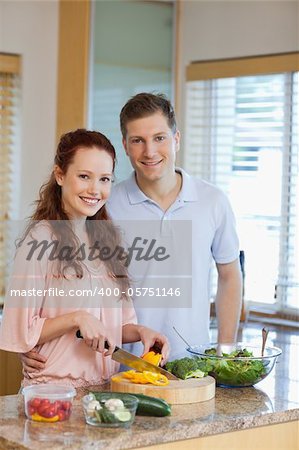 Male watching his girlfriend preparing a green salad