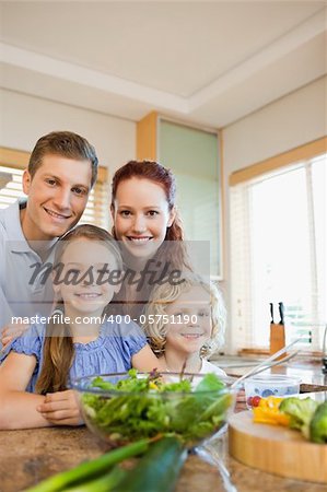 Young family standing together behind the kitchen counter