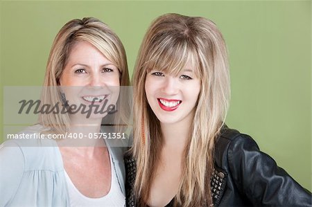 Happy mom and daughter smile over green background
