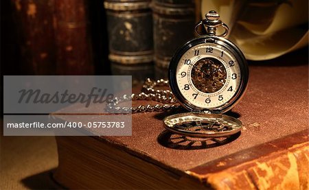 Still life with stylish pocket watch on ancient book