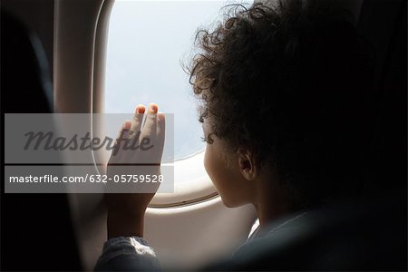Boy looking out airplane window