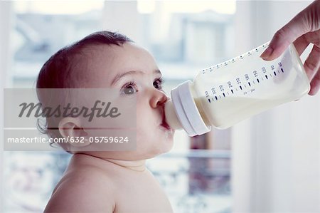 Infant drinking milk from baby bottle