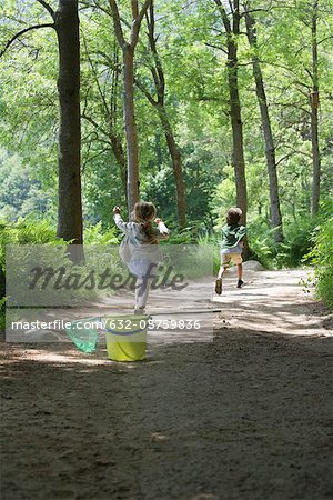 Children running on path through woods