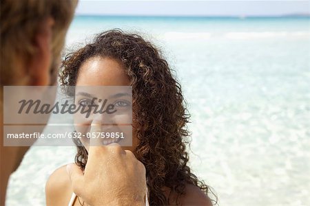 Couple at the beach, man touching woman's nose