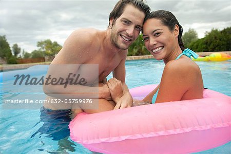 Couple together in swimming pool, portrait