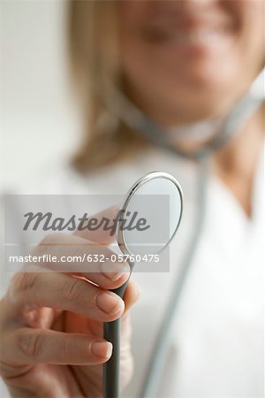 Doctor holding out stethoscope, cropped
